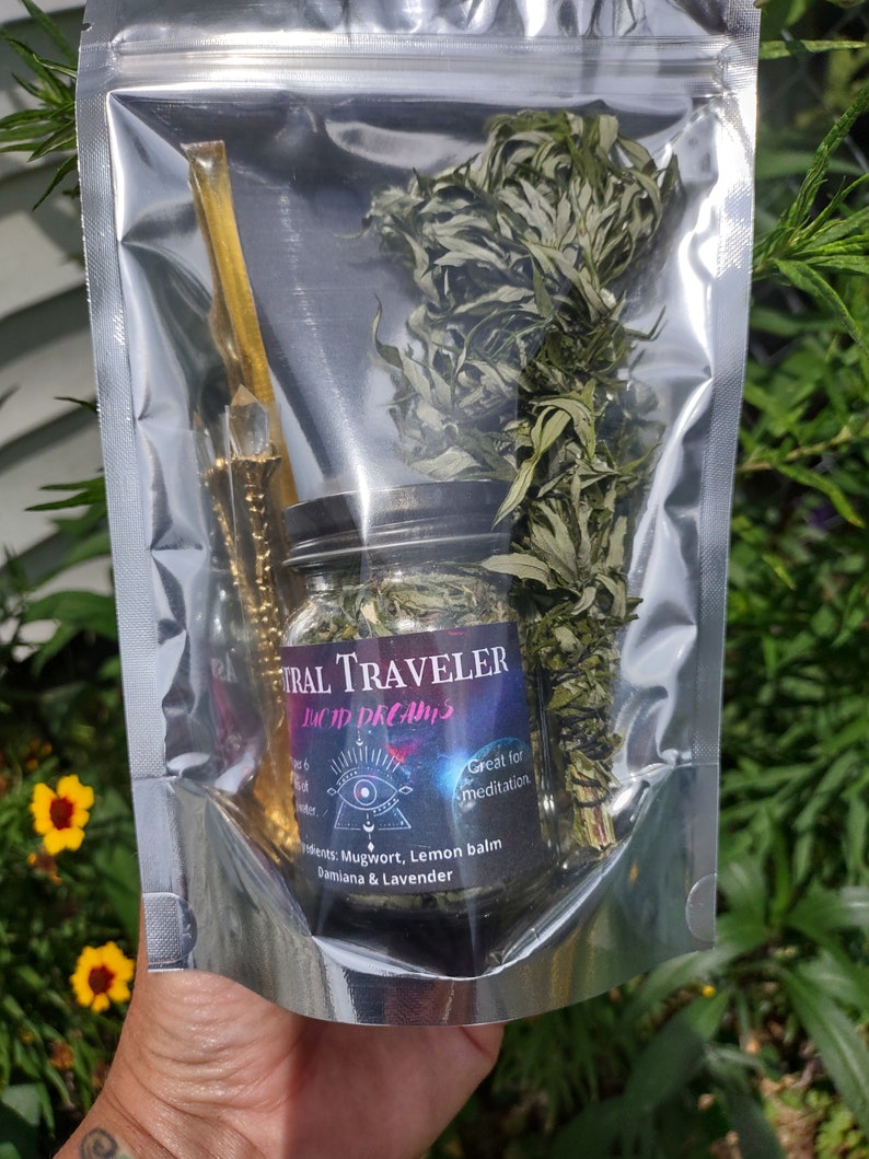 Puede incluir: Una bolsa de pl&aacute;stico transparente que contiene un frasco de vidrio lleno de hierbas secas, una varita dorada y un peque&ntilde;o manojo de hierbas secas. El frasco tiene una etiqueta negra que dice "FIRAL TRAVELER LUCID DREAMS" y "Ideal para la meditaci&oacute;n". La etiqueta tambi&eacute;n enumera los ingredientes: "Ajenjo, melisa, damiana y lavanda".