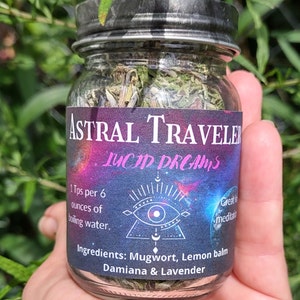 Puede incluir: Un frasco de vidrio lleno de hierbas secas etiquetado como "Astral Traveler Lucid Dreams". La etiqueta tambi&eacute;n incluye instrucciones de uso: "1 Tps por 6 onzas de agua hirviendo." y enumera los ingredientes: "Ajenjo, b&aacute;lsamo de lim&oacute;n, damiana y lavanda."