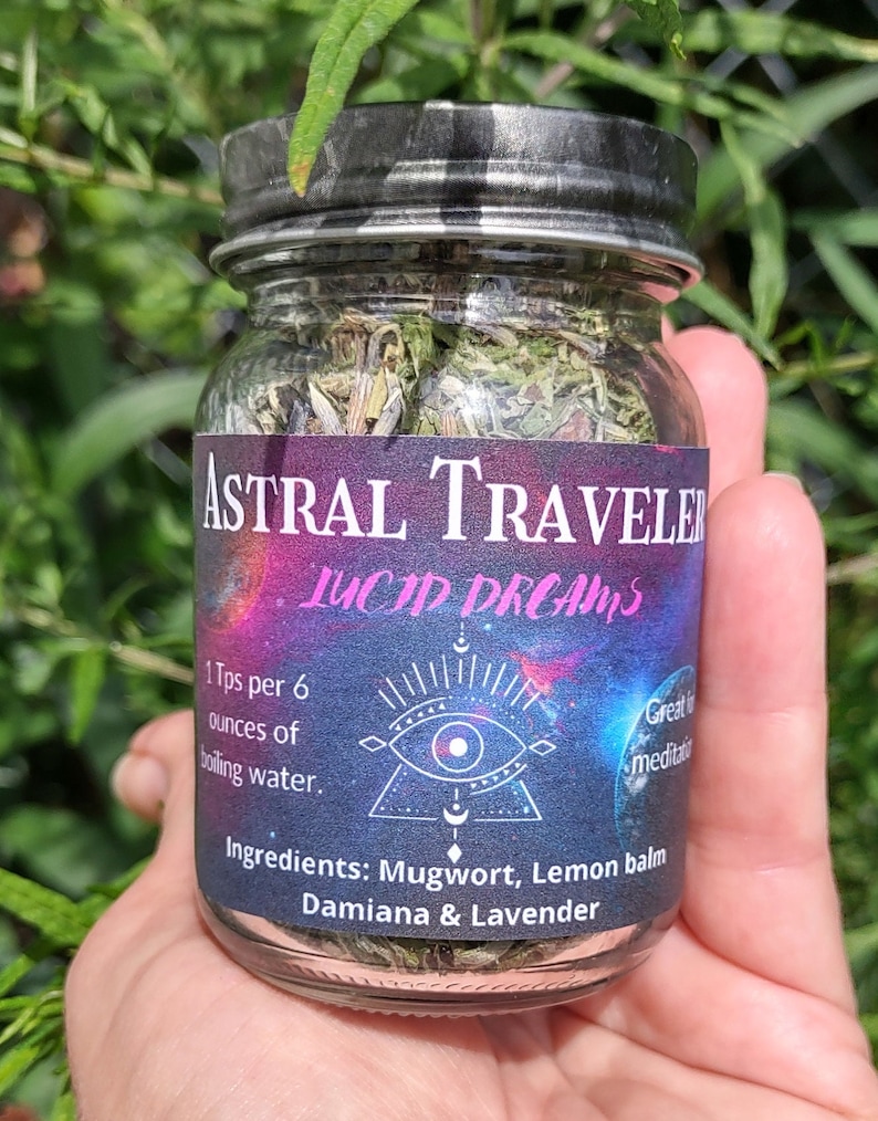 Puede incluir: Un frasco de vidrio lleno de hierbas secas etiquetado como "Astral Traveler Lucid Dreams". La etiqueta tambi&eacute;n incluye instrucciones de uso: "1 Tps por 6 onzas de agua hirviendo." y enumera los ingredientes: "Ajenjo, b&aacute;lsamo de lim&oacute;n, damiana y lavanda."