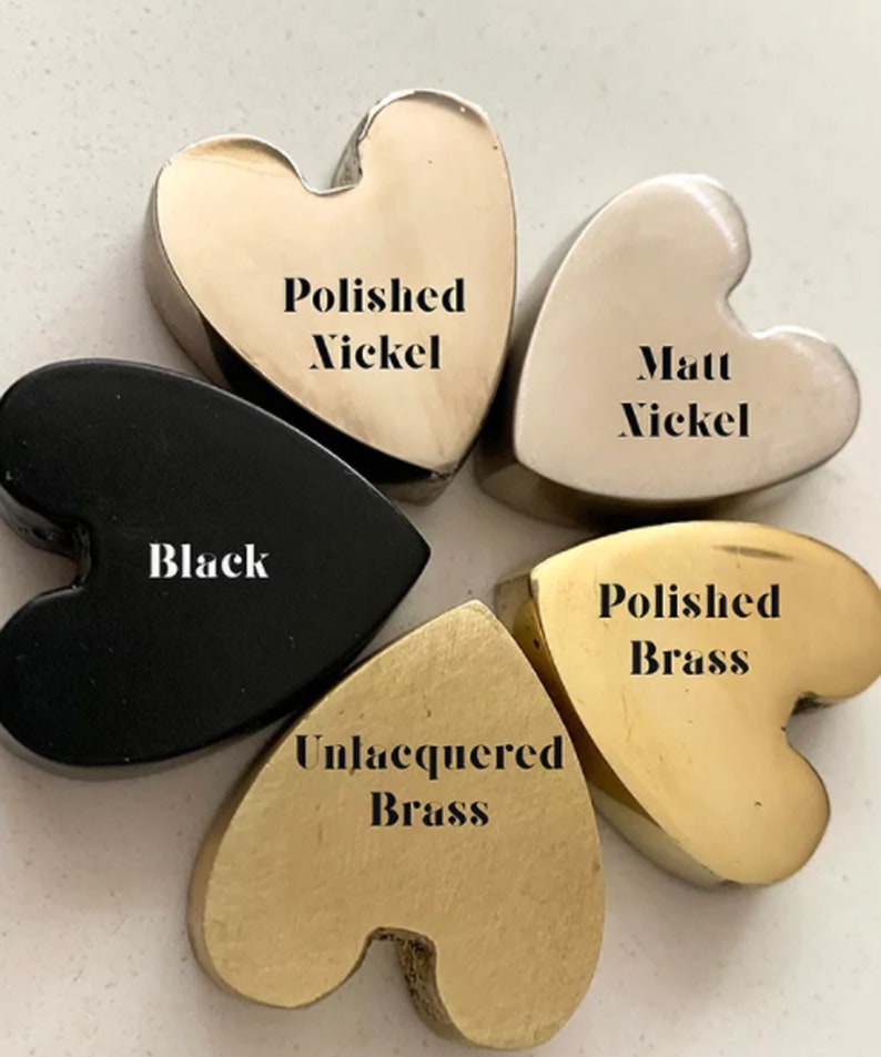 May include: Five heart-shaped metal samples in different finishes: polished nickel, matte nickel, black, polished brass, and unlacquered brass.