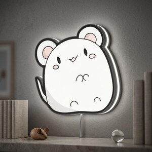 May include: A white, cartoon mouse-shaped wall light with a black outline and pink inner ears. The light has a soft glow around the edges and a small tail. A wooden mouse figurine sits on a shelf below.