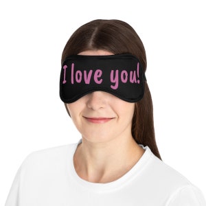 May include: Black sleep mask with the words "I love you!" printed in pink.