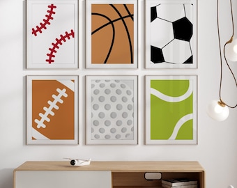 May include: A set of six framed prints featuring different sports equipment, including a baseball, basketball, soccer ball, football, golf ball, and tennis ball. The prints are all white with black outlines and are arranged in a grid pattern on a white wall.