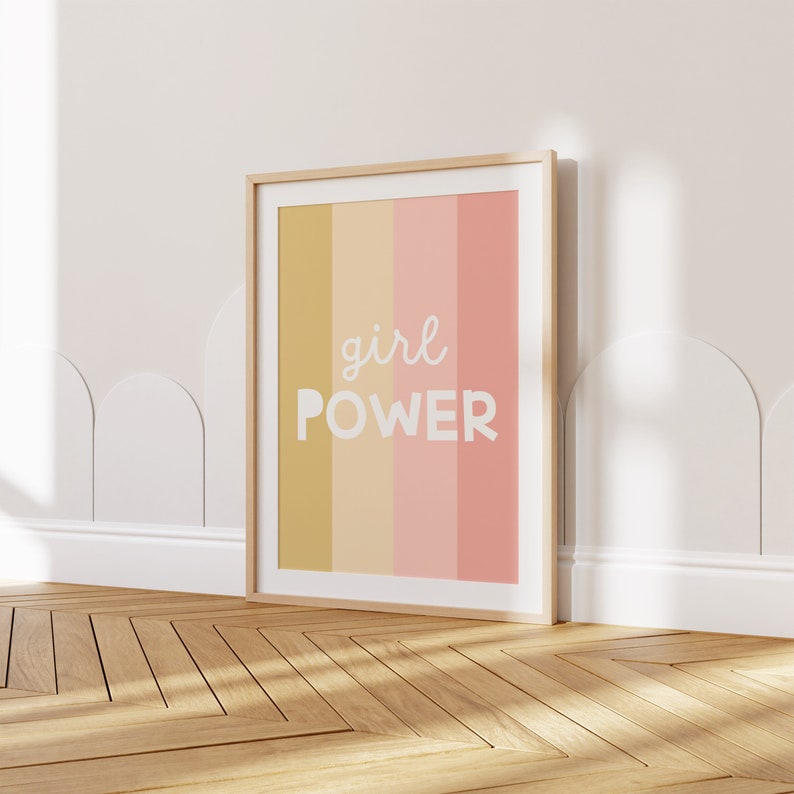 May include: A framed print with a colorful striped background and the text "girl POWER" in white.