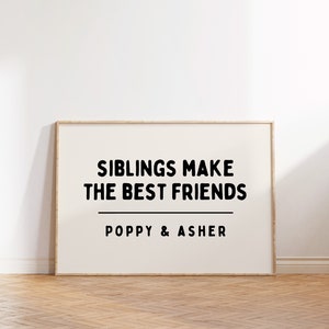 May include: A framed print with the text "Siblings make the best friends" and the names "Poppy & Asher" below. The print is on a white background with a wooden frame.