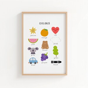 May include: A framed print titled "COLORS" features colorful illustrations of objects representing different colors. The colors include yellow, orange, red, pink, grey, blue, purple, green, white, brown, and black. The print is in a light wood frame.
