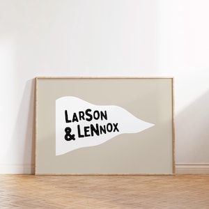 May include: A framed print with a white pennant design on a beige background. The pennant has the text "LARSON & LENNOX" in black.