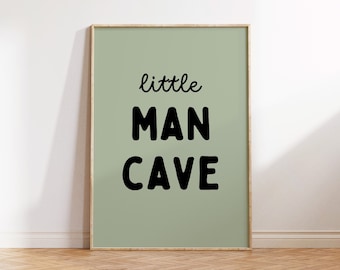 May include: A framed print with a sage green background and black text that reads "little man cave".