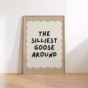 Puede incluir: Una impresi&oacute;n enmarcada con un fondo beige y un dise&ntilde;o en forma de nube blanca. El texto "THE SILLIEST GOOSE AROUND" est&aacute; escrito en negro dentro de la nube.