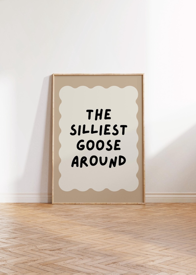 Puede incluir: Una impresi&oacute;n enmarcada con un fondo beige y un dise&ntilde;o en forma de nube blanca. El texto "THE SILLIEST GOOSE AROUND" est&aacute; escrito en negro dentro de la nube.