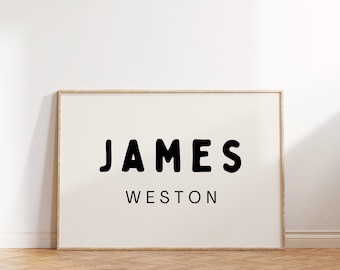 May include: A framed print with the name "JAMES WESTON" in black, bold, bubble-like letters on a white background.