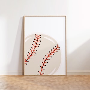 Op de afbeelding: Een ingelijst afdruk van een honkbal met rode stiksels op een beige achtergrond.