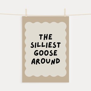 Puede incluir: Una impresi&oacute;n de arte de pared beige imprimible con un borde ondulado y el texto "THE SILLIEST GOOSE AROUND" en negro.