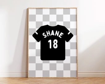 May include: A framed print of a black and white jersey with the name "SHANE" and the number "18" on the back. The jersey is on a checkered background.