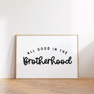 May include: A framed print with the text "All good in the brotherhood" in a black cursive font on a white background.