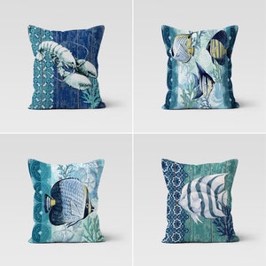Peut inclure: Quatre coussins décoratifs sur le thème nautique. Les coussins sont de couleur bleu et vert avec des images de poissons, un homard et des coraux. Les coussins sont faits d'un tissu doux et confortable.