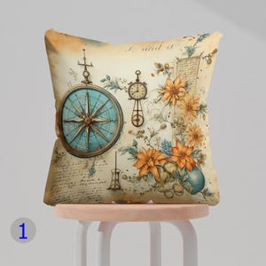 May include: A decorative cushion with a vintage design featuring a compass, a clock, and floral elements. The background is a cream colour with handwritten text that reads "I and a".
