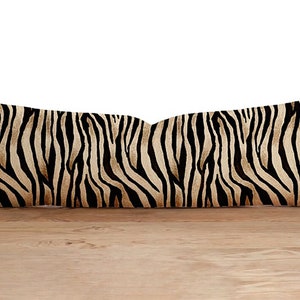 Peut inclure: Un coussin long et rectangulaire avec un imprimé zèbre noir et marron.