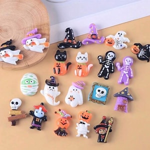 May include: A collection of 18 Halloween themed resin charms. The charms feature various Halloween characters and symbols, including ghosts, pumpkins, cats, skeletons, and witches. The charms are all in bright colors and have a cute, cartoonish style.
