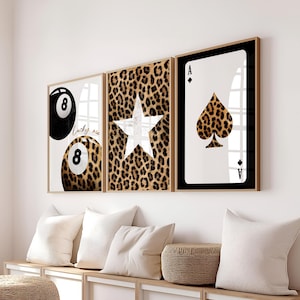 May include: Three framed art prints. The first features a black and leopard print 8-ball with the text "Lucky me". The second has a white star on a leopard print background. The third is an Ace of Spades card with a leopard print spade.