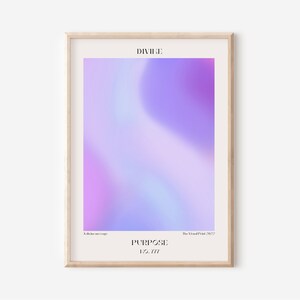 Könnte beinhalten: Ein gerahmter Kunstdruck mit einem weichen, verschwommenen Farbverlauf in Lila- und Blautönen. Das Wort "DIVINE" steht oben, mit "PURPOSE" und "No. 777" unten. Der Druck ist in einem hellen Holzrahmen.
