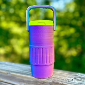 Puede incluir: Una botella de agua vibrante con asa y dise&ntilde;o degradado. La botella presenta una transici&oacute;n de morado a azul, con una tapa verde ne&oacute;n y un asa que se desvanece de azul a verde. Tiene una secci&oacute;n acanalada para el agarre.