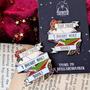 May include: Two gold enamel pins with a book stack design. The top pin reads "Plot Twist I Bought More Books". The bottom pin reads "Plot Twist I Bought More Books".
