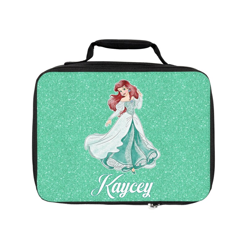 May include: A green glitter lunch bag with a black handle and zipper. The bag features a cartoon image of Ariel from The Little Mermaid and the name "Kaycey" printed on the front.