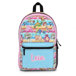 May include: A pink and blue backpack with a colorful pattern of Toy Story characters. The backpack has a large front pocket with the name "Leia" written in pink.