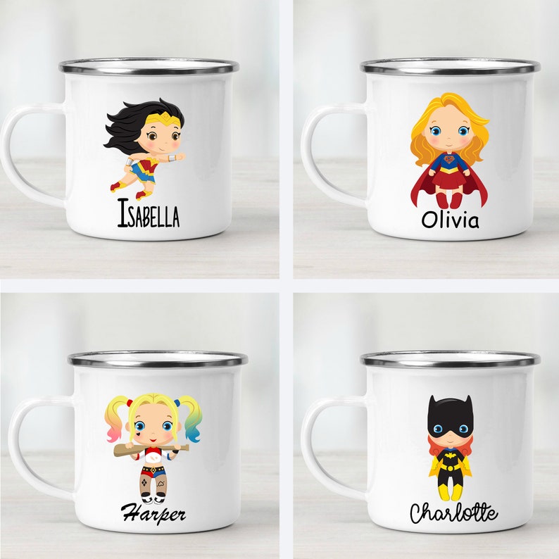 Peut inclure: Quatre tasses en &eacute;mail blanc avec des bords argent&eacute;s, chacune repr&eacute;sentant une fille de dessin anim&eacute; diff&eacute;rente en super-h&eacute;ro&iuml;ne. Les tasses sont &eacute;tiquet&eacute;es avec les noms "Isabella", "Olivia", "Harper" et "Charlotte".