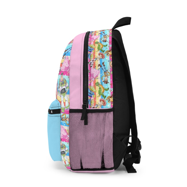 May include: A pink backpack with a colorful pattern of characters from the Toy Story franchise. The backpack has a mesh pocket on the side and a blue zippered pocket on the front.