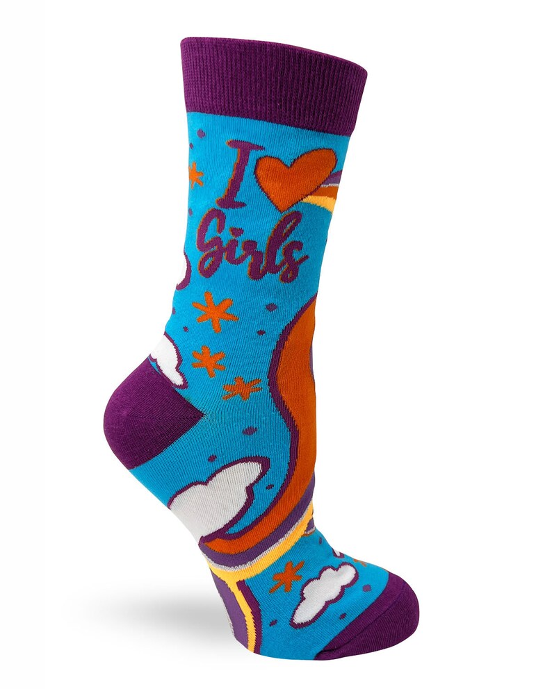 May include: A pair of blue socks with a rainbow, clouds, and stars pattern. The socks have a purple cuff and the text "I love girls" is printed on the front.