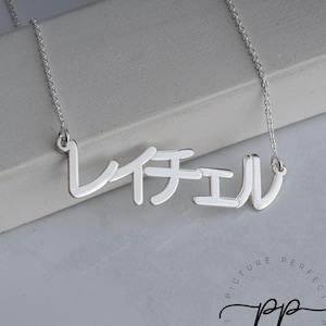 May include: A silver necklace with a nameplate pendant that reads "MICHAEL" in a stylized font.