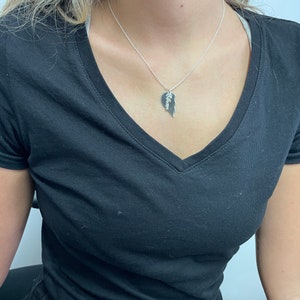 May include: A silver necklace with a heart-shaped pendant that is split in half. The pendant has the word "Allison" engraved on it.