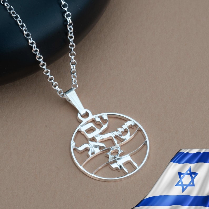 May include: Silver necklace with a round pendant featuring Hebrew text and a Star of David. The pendant is a cutout design, revealing the background through the letters.