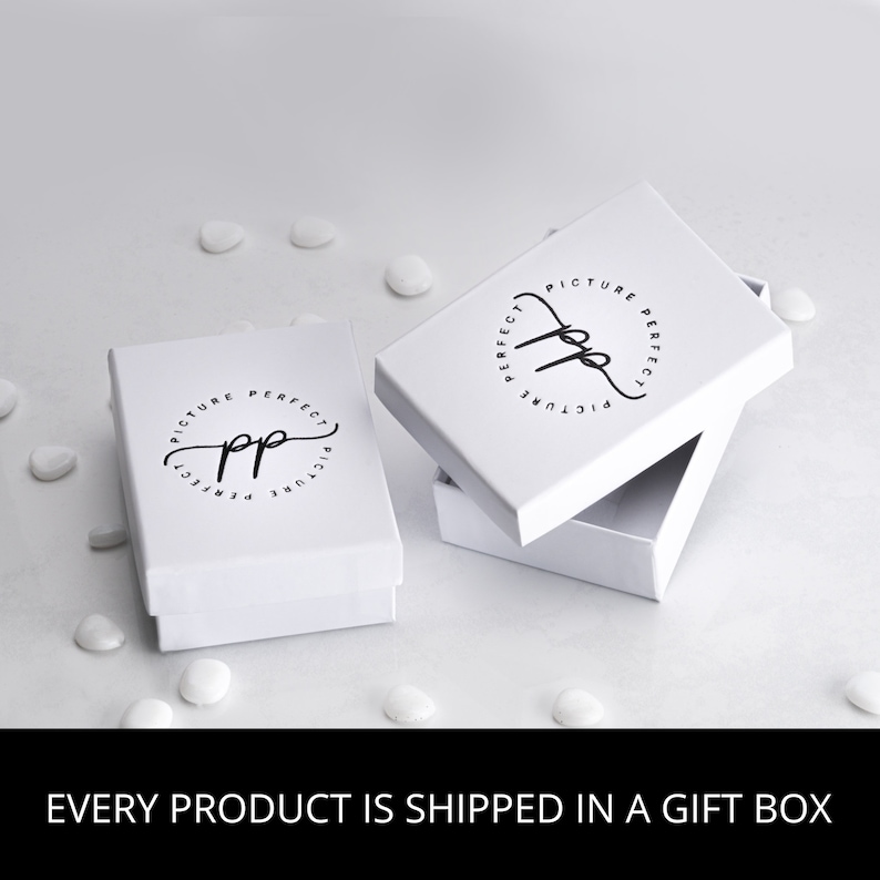 May include: White gift box with a black logo that says "Picture Perfect" in a circle. The box is open and the inside is white.