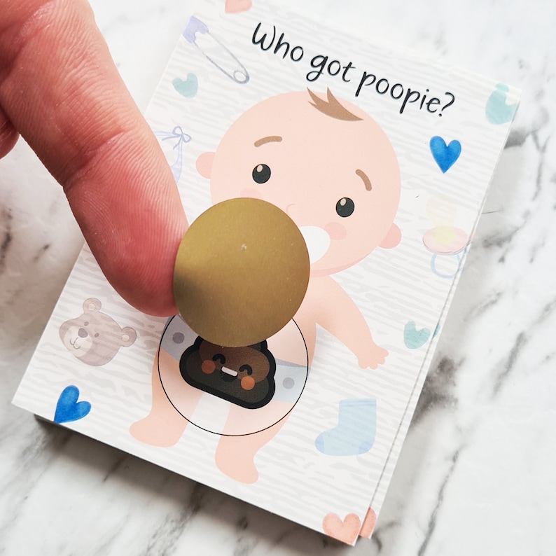 K&ouml;nnte beinhalten: Ein Baby-Spiel mit dem Text "Wer hat gepupst?" Ein Cartoon-Baby tr&auml;gt eine Windel mit einem braunen Poop-Emoji-Aufkleber darauf. Ein goldener Aufkleber wird &uuml;ber das Poop-Emoji gelegt.