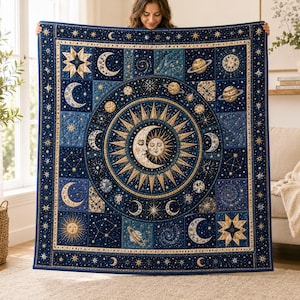 May include: A rectangular quilt featuring a celestial theme with a deep blue background. The center displays a large sun and moon motif surrounded by golden rays. The surrounding grid pattern includes various planets, stars, and crescent moons.