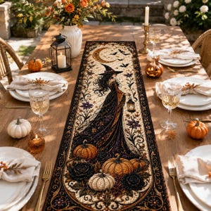 May include: A rectangular table runner featuring a central illustration of a witch in a long gown holding a lantern, surrounded by pumpkins, roses, and a crescent moon. The design includes flying bats and ornate floral borders in black and gold.