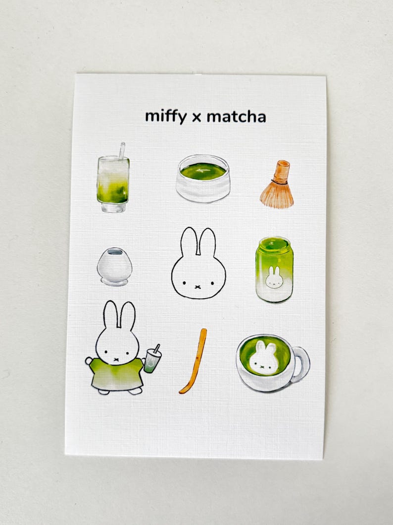 Op de afbeelding: Een witte kaart met de tekst "miffy x matcha" en illustraties van matcha-gerelateerde items. Deze omvatten een matcha-drankje, een kom matcha, een garde, een kleine container, een Miffy-konijn, een pot en een kopje matcha.