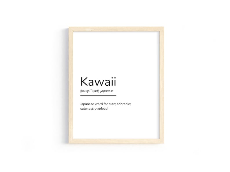 May include: A framed print with the word "Kawaii" in black text on a white background. The definition of the word is provided in smaller text below: "[kawai'i] adj, Japanese. Japanese word for cute; adorable; cuteness overload."