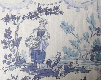 May include: A fabric with a toile design in shades of blue and white. The scene depicts a woman with a basket, trees, and birds. The fabric has a repeating pattern with a classic, vintage aesthetic.