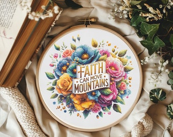 May include: A round embroidery hoop featuring a floral design with blue, pink, and yellow flowers. The text "FAITH CAN MOVE MOUNTAINS" is centered on a banner. The hoop is set against a neutral background with a book and greenery.