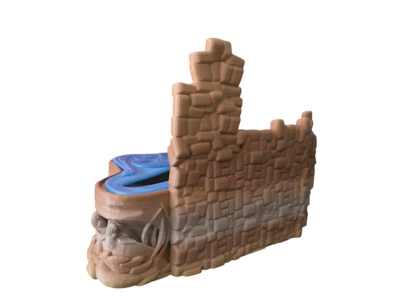 K&ouml;nnte beinhalten: Ein braunes Plastik-Spielschloss mit einem blauen Wasserfeature. Das Schloss hat einen hohen Turm und eine Mauer mit einem Tor. Das Spielset ist f&uuml;r Kinder zum Spielen konzipiert.