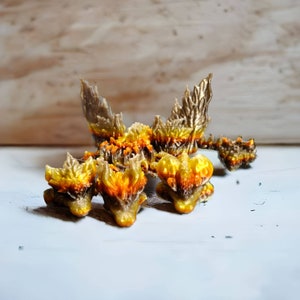 May include: A group of five small, golden, and brown ceramic dragon figurines. The dragons are arranged in a cluster, with their heads facing different directions. The dragons have intricate details, including scales, wings, and claws.