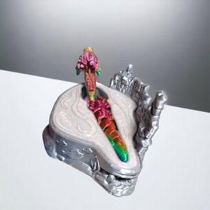 K&ouml;nnte beinhalten: Eine silberne 3D-gedruckte Drachenfigur mit schillernden Schuppen, die auf einem silbernen Sockel mit strukturierter Oberfl&auml;che sitzt. Der Kopf des Drachen ist erhoben und seine Fl&uuml;gel sind ausgebreitet.