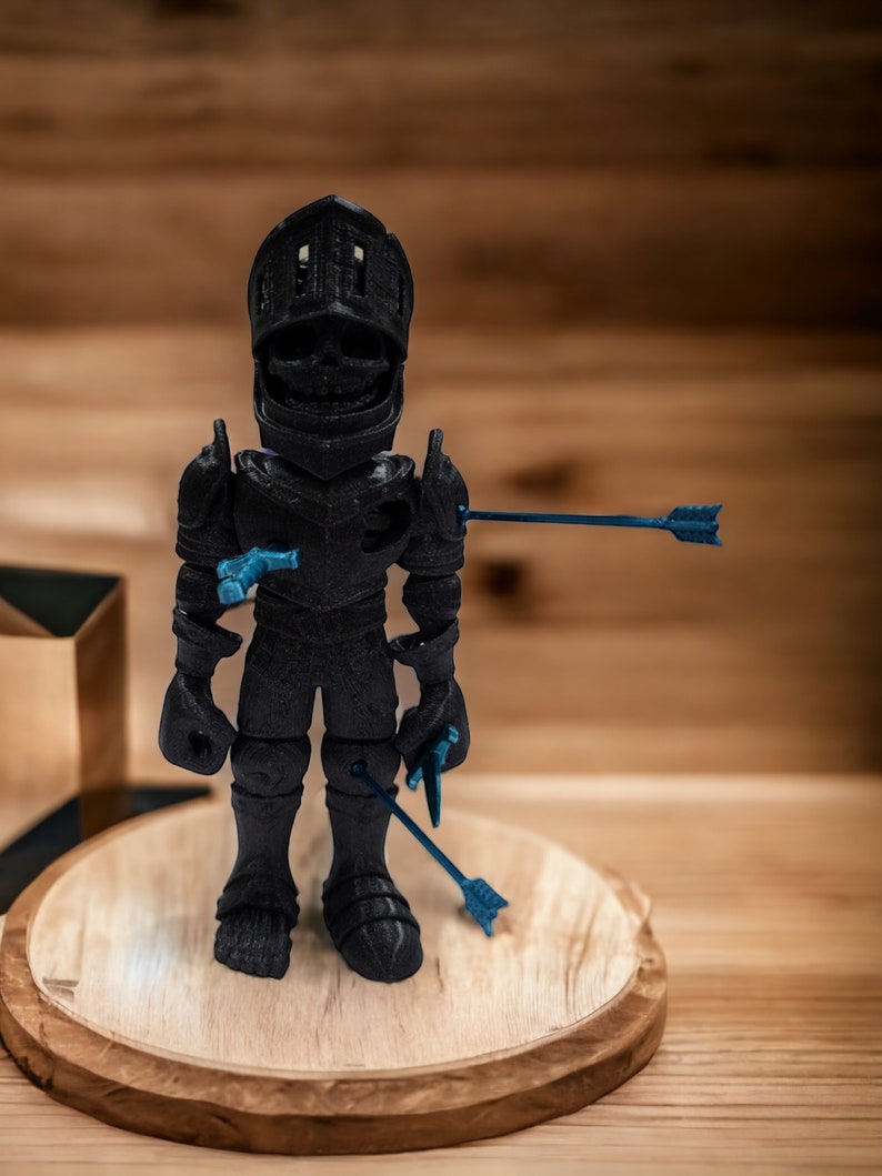 May include: A black 3D printed figurine of a knight wearing armor and a helmet. The knight is pierced by several blue arrows. The figurine is standing on a wooden base.