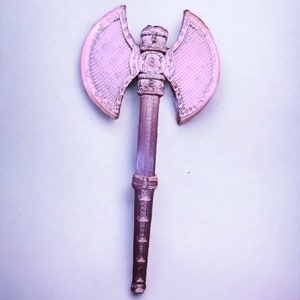 May include: A pink plastic toy axe with a double-headed blade and a detailed handle.