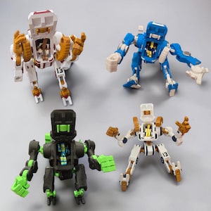May include: Four colorful robot toys in white, blue, black, and white with gold and green accents. Each robot has articulated limbs and a central compartment. The robots are posed in various action stances, showcasing their design and features.