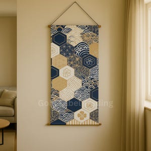 May include: A wall hanging with a geometric pattern of navy blue, gold, and cream-colored hexagons. The design includes floral and wave motifs. The text "Go...bel...ing" is visible at the bottom. The hanging is suspended from a wooden rod.